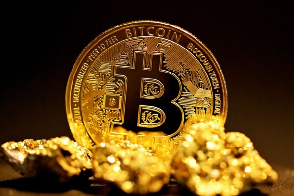 Bitcoin on top of pile of gold