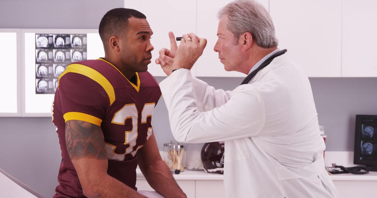 A doctor examining a football player