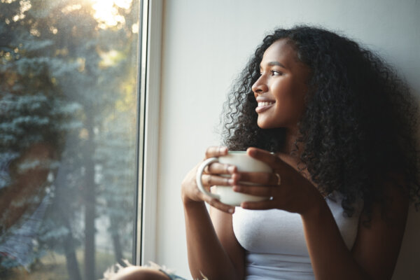Woman enjoying her morning coffee by the window