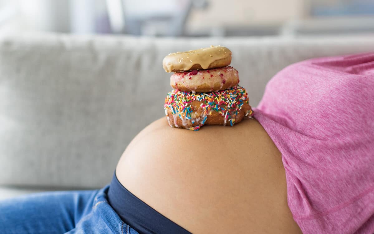 Pregnant woman with donuts on belly