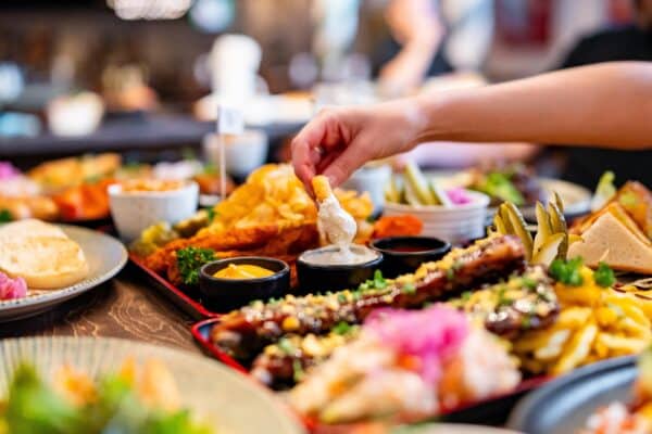 Processed food and high-fat diet: Person dipping french fries in sauce