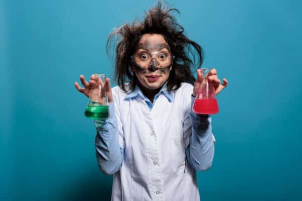 Scientist after an experiment explosion holding two beakers