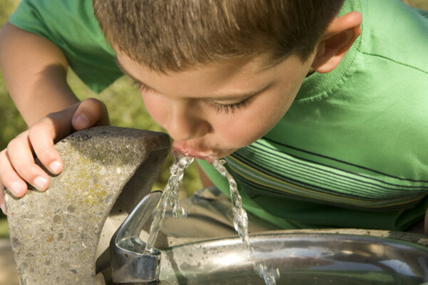 Boy drinking from a water fountain