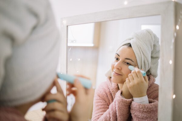 Woman using instant wrinkle eraser while looking at herself in the mirror